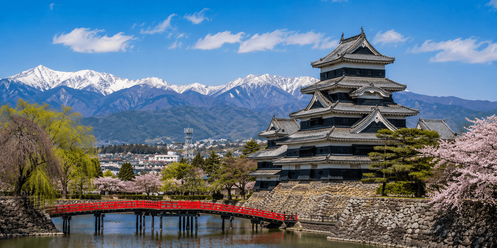 The black and white keep of Matsumoto Castle reflected in its moat, with the snow-capped Northern Japan Alps behind