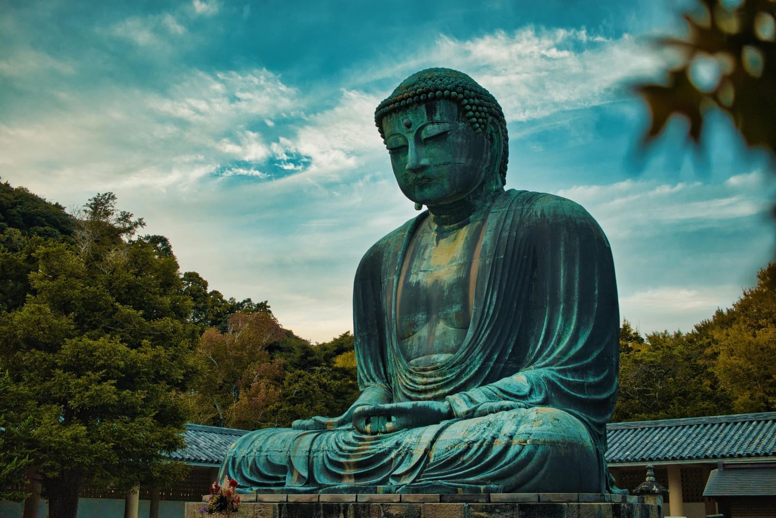 Low-angle view of the Great Buddha of Kamakura against a blue sky in Kotoku-in's open-air courtyard