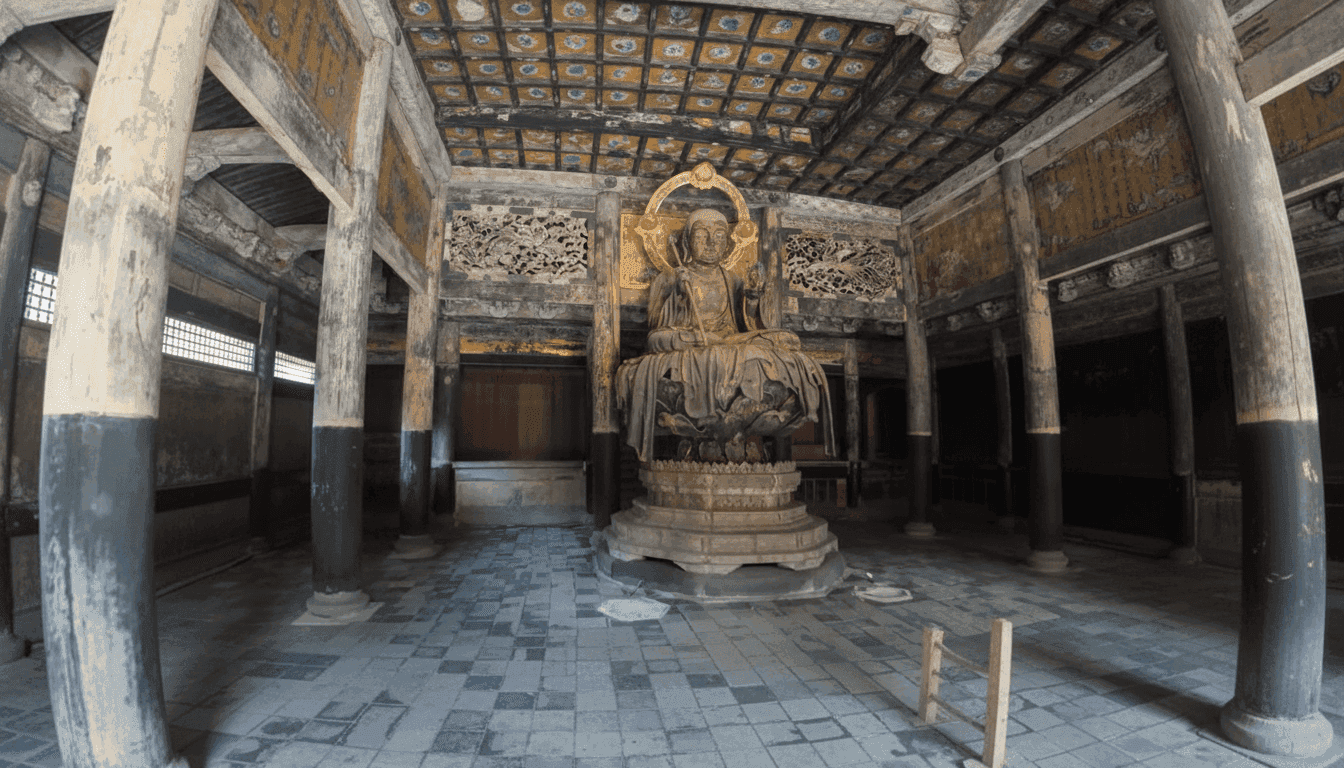 Seated Jizo statue with a staff inside a temple hall with a gilded coffered ceiling