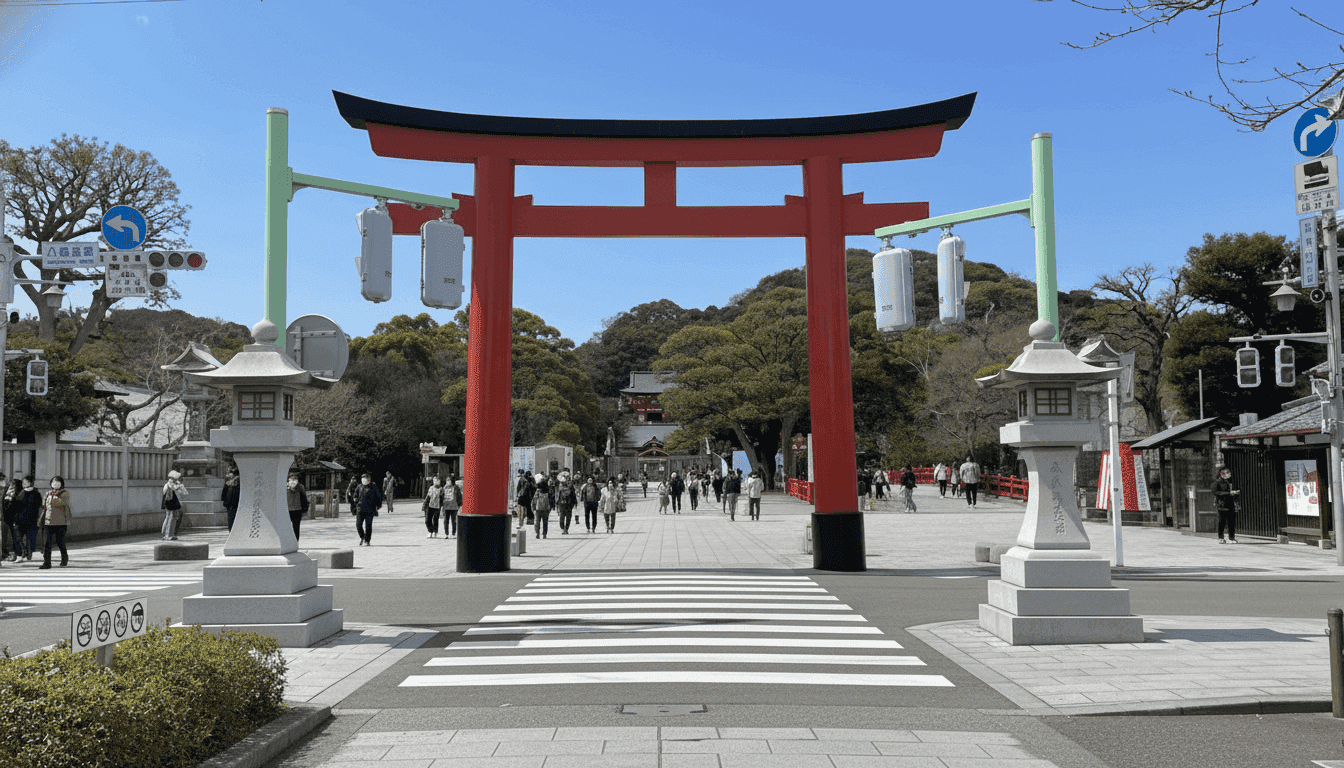 Torii gate and stone lanterns at the pedestrian crossing entrance to Tsurugaoka Hachimangu Shrine in Kamakura