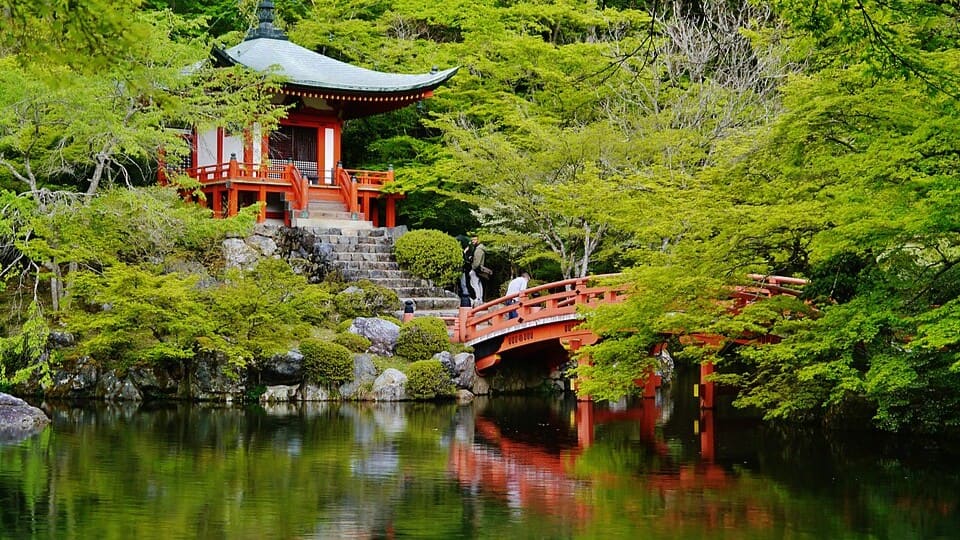 Daigo-ji's vermilion Bentendo hall and bridge above its pond, among fresh green maples