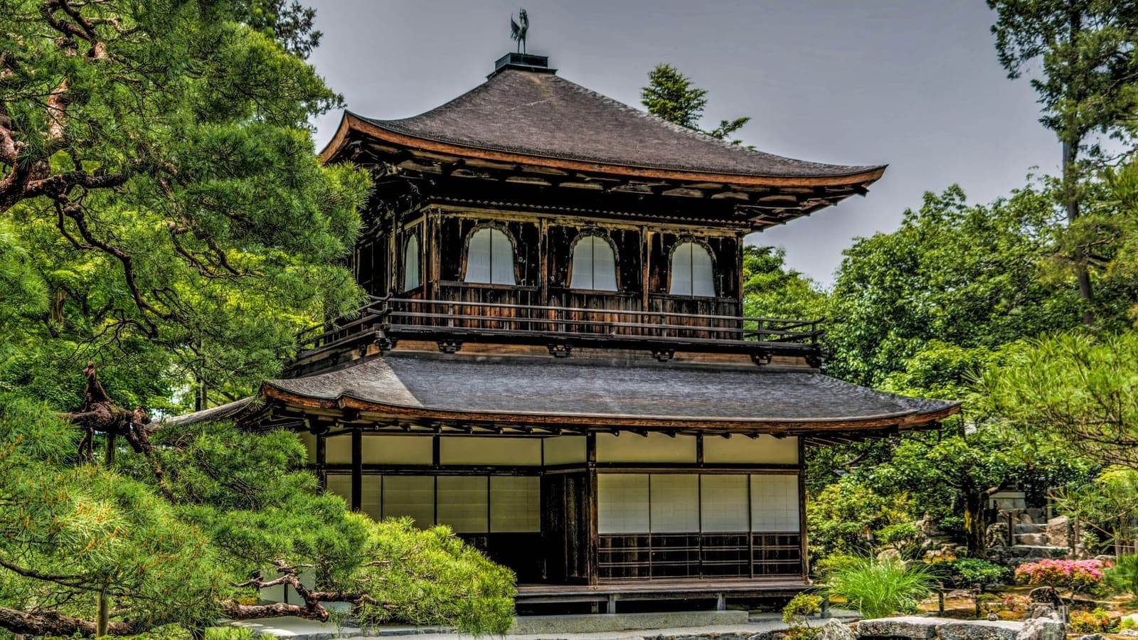 The two-story Silver Pavilion (Kannon Hall) with its bronze phoenix on the roof, framed by pines