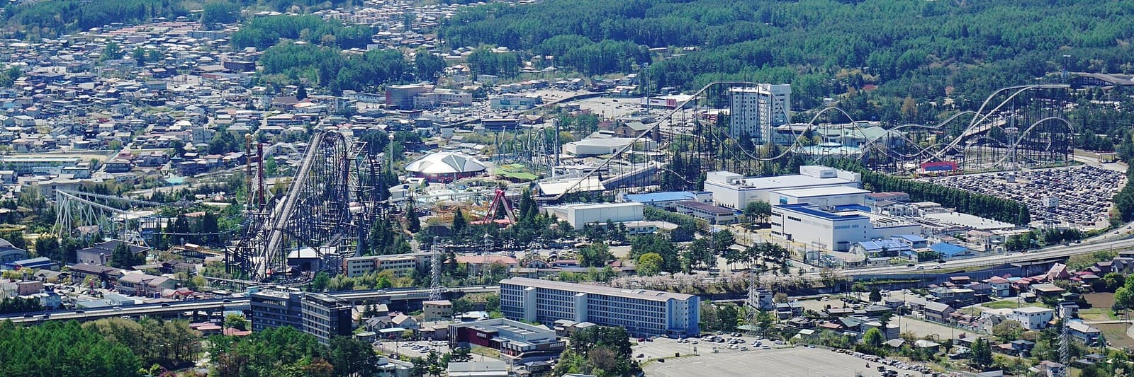 Fuji-Q Highland's roller coasters and parking lots in Fujiyoshida, seen from Mount Tenjo above Lake Kawaguchiko