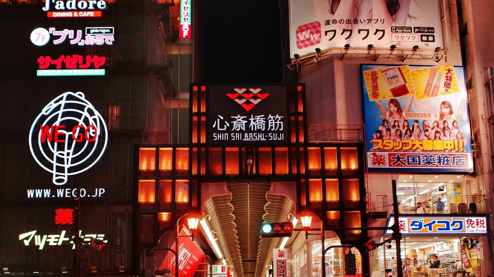 Shinsaibashi Shopping Street covered arcade with glass roof and pedestrians browsing storefronts, Osaka Japan