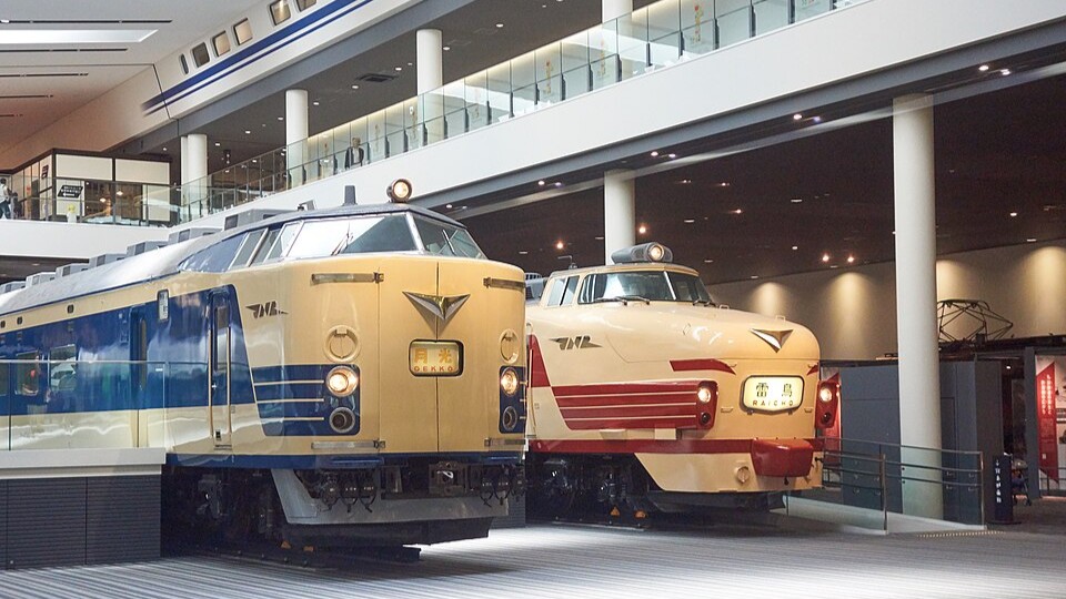 A 581-series sleeper train with a Gekko headboard beside a 489-series Raicho express in the Kyoto Railway Museum's main hall